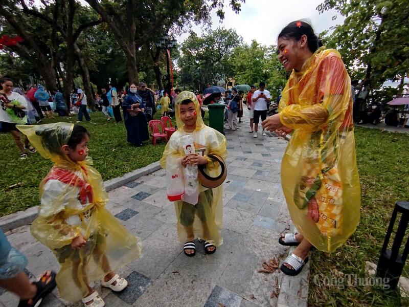 Ba mẹ con chị Thủy nhanh chóng chuẩn bị cho mình những chiếc áo mưa.