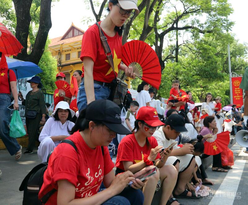Người dân ngồi chờ xem tổng hợp luyện diễu binh, diễu hành từ sớm tại khu vực Quảng trường Ba Đình. Ảnh: Hoa Quỳnh