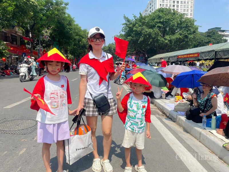 Thời tiết nắng nóng, người dân chủ động mang mũ nón với cờ đỏ sao vàng...