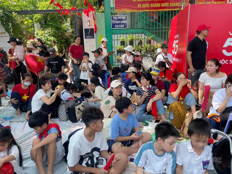 Người dân mang theo bạt, chiếu trải xuống vỉa hè ngồi nghỉ trong thời gian chờ đợi.