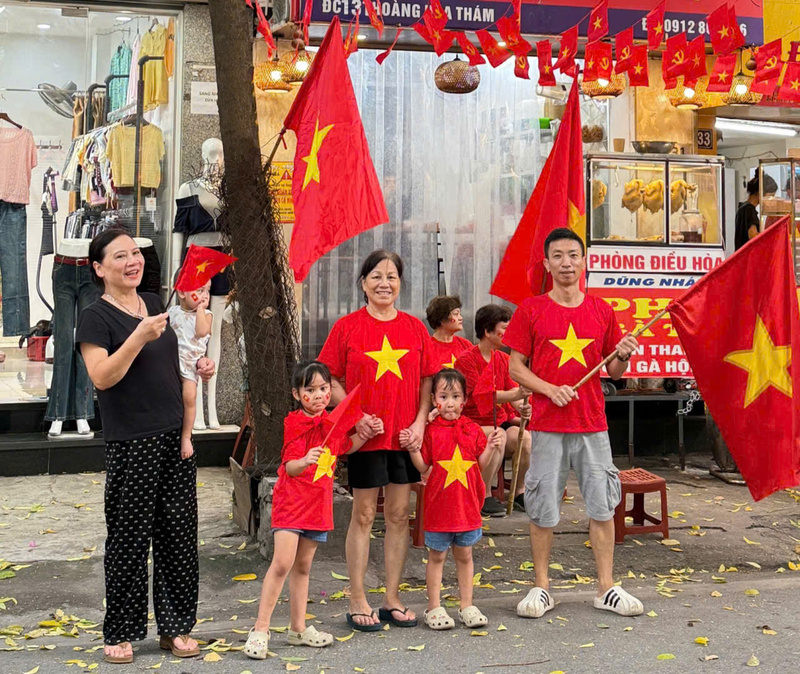 Gia đình bà Nguyễn Thị Vân vừa mua áo đỏ sao vàng, cờ Tổ quốc trên đường Hoàng Hoa Thám và cho các cháu mặc ngay, hòa chung không khí hướng tới Quốc khánh 2/9.
