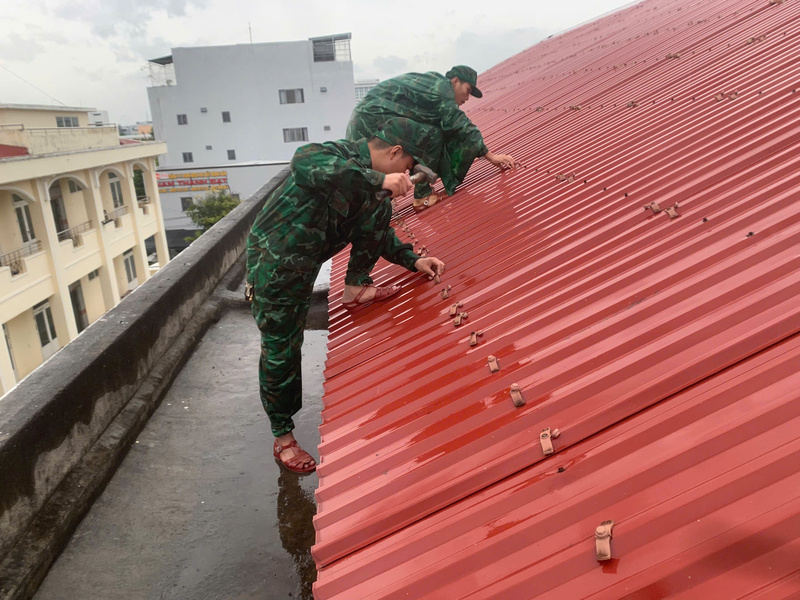 Các chiến sĩ Đồn biên phòng Non Nước (phường Ngũ Hành Sơn) giúp người dân chằng chống nhà cửa. Ảnh: Bình An