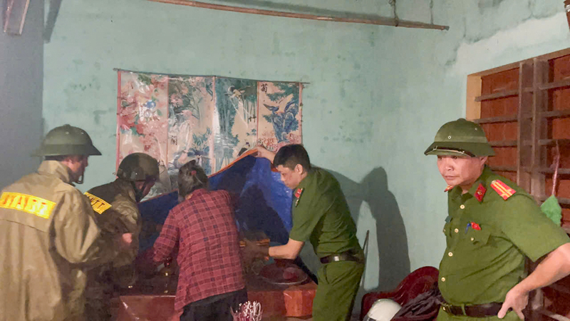 Công an xã giúp người dân kê cao đồ đạc, dọn dẹp nhà cửa tránh nước lũ dâng lên. Ảnh: Công an Hà Tĩnh