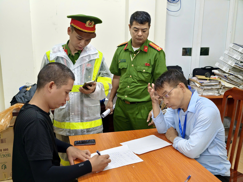 Lực lượng chức năng phường Ba Đình lập biên bản xử lý vi phạm hành chính trường hợp lập bãi trông giá xe trái phép trước buổi sơ duyệt A80. Ảnh: Trung Nguyên