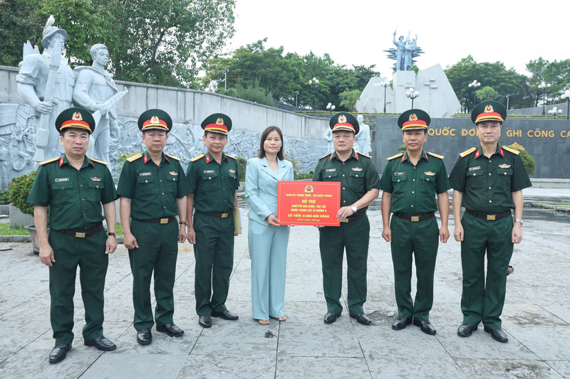 Thiếu tướng Nguyễn Đức Tăng, Phó Chính ủy Tổng cục Công nghiệp quốc phòng trao quà của Quân ủy Trung ương, Bộ Quốc phòng tặng Ban quản lý Nghĩa trang Liệt sỹ quốc gia Đường 9. Ảnh: Nam Đăng