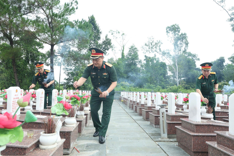 Các thành viên trong đoàn thắp hương tưởng nhớ các Anh hùng liệt sỹ tại Nghĩa trang Liệt sỹ quốc gia Trường Sơn. Ảnh: Nam Đăng