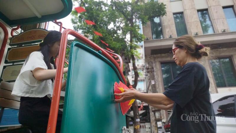 Người dân trang trí thêm cho mô hình Toa thóc lúa gạo trên phố Trúc Bạch.