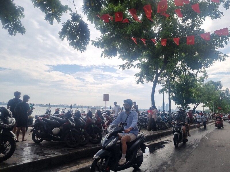 Hàng dài xe máy xếp sát bồn hoa ven Hồ Tây, biến không gian công cộng thành bãi trông giữ tự phát. Ảnh: Văn Thi