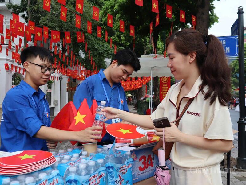 Người dân hào hứng, sôi nổi nhận quạt, nước - Ảnh: Phương Trang