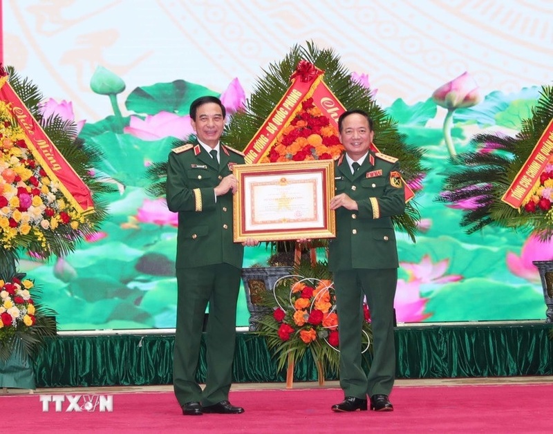 Thừa ủy quyền của Chủ tịch nước, Đại tướng Trịnh Văn Quyết, Bí thư Trung ương Đảng, Ủy viên Thường vụ Quân ủy Trung ương, Chủ nhiệm Tổng cục Chính trị Quân đội Nhân dân Việt Nam trao Huân chương Quân công hạng Nhất cho Đại tướng Phan Văn Giang, Ủy viên Bộ Chính trị, Phó Bí thư Quân ủy Trung ương, Bộ trưởng Bộ Quốc phòng. Ảnh: Trọng Đức/TTXVN