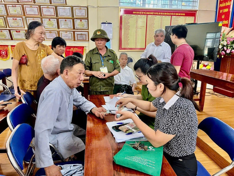 Bà con nhân dân phường Tân Hòa hân hoan nhận quà của Chính phủ tại điểm phát quà. Ảnh: CTV