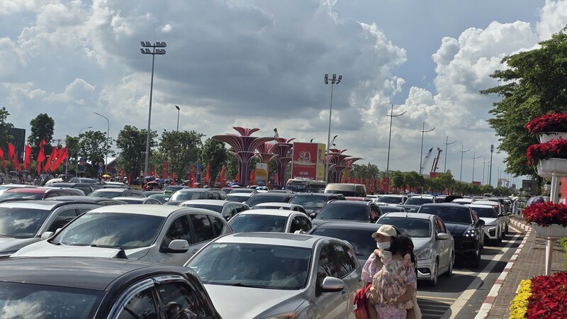 Hướng di chuyển đi Trung tâm Triển lãm Quốc gia ùn tắc kéo dài, đặc biệt là trong làn ô tô chỉ có thể nhích từng chút, gia đình chị Dung gửi xe bên ngoài và bế con đi bộ vào khu triển lãm