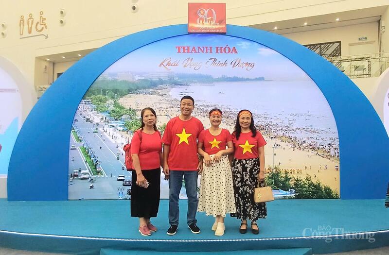 Người dân chụp ảnh lưu niệm tại cổng chào khu trưng bày