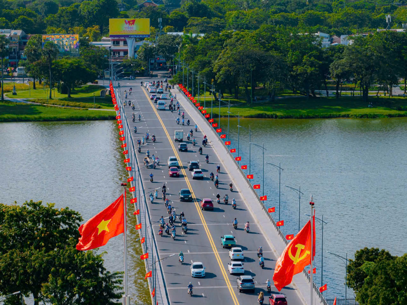 Cầu Phú Xuân nối hai bờ sông Hương sắc đỏ cờ Tổ quốc rực rỡ hai bên, hoà nhịp cùng dòng người hối hả chào mừng ngày Quốc khánh 2/9. Ảnh: L. Hoàng