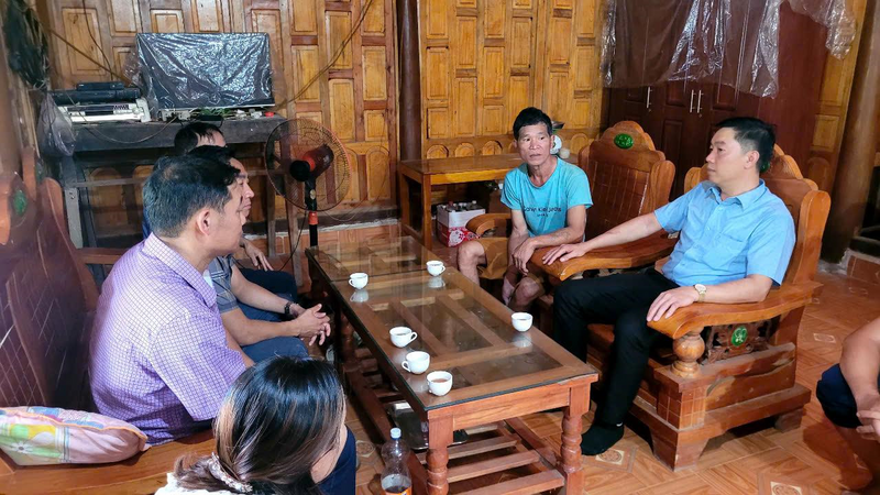 Cán bộ xã tuyên truyền, vận động người dân chuyển đổi cơ cấu cây trồng trên nương sang các loại cây trồng có giá trị kinh tế cao. Ảnh: Nhật Phương