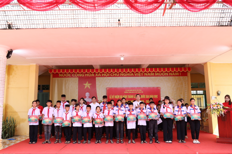Ông Ngô Đức Bình, Phó Chủ tịch Công đoàn Vietcombank (bên phải) và ông Nguyễn Minh Tuấn, Giám đốc Vietcombank - Chi nhánh Tuyên Quang trao học bổng cho các em học sinh Trường THCS Trung Yên và Trường THCS Kim Quan