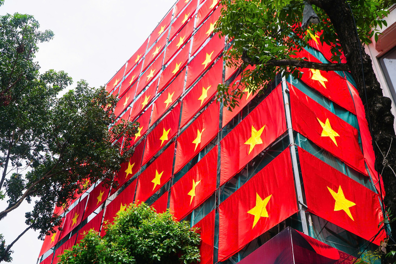 Cờ đỏ sao vàng được treo tại một tòa nhà dọc phố Đinh Tiên Hoàng, phía sau tòa nhà Hàm cá mập cũ. Bên trong, các công nhân vẫn đang tiến hành chỉnh trang, cải tạo. Ảnh: Phạm Tuấn