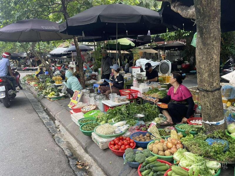 Chợ tạm khu Trung Hòa, hàng hóa bày sát mép đường.