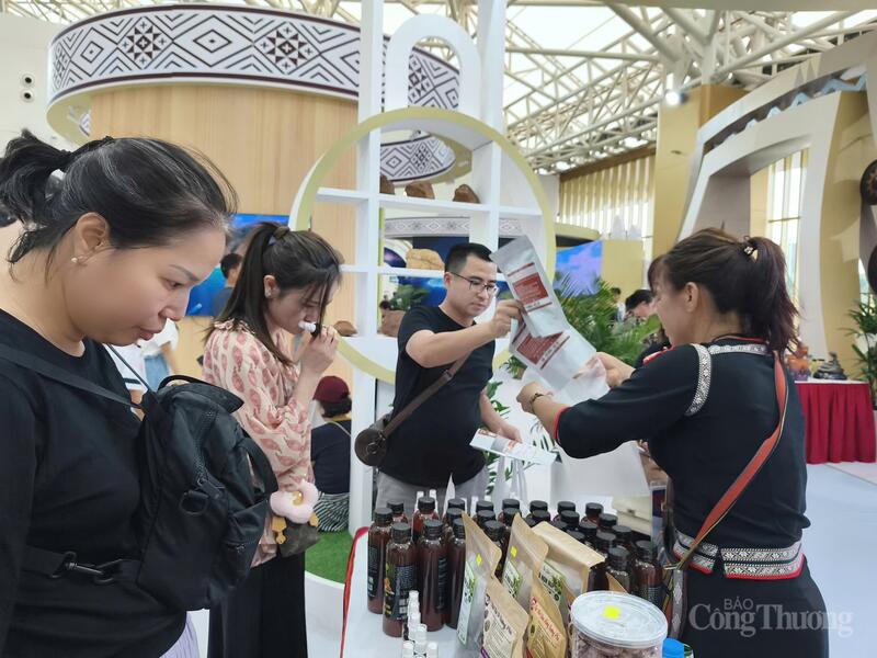 Chị Phạm Thị Bình (ngoài cùng bên phải) đang bán hàng cho khách tại triển lãm. Ảnh: Nguyễn Hoà