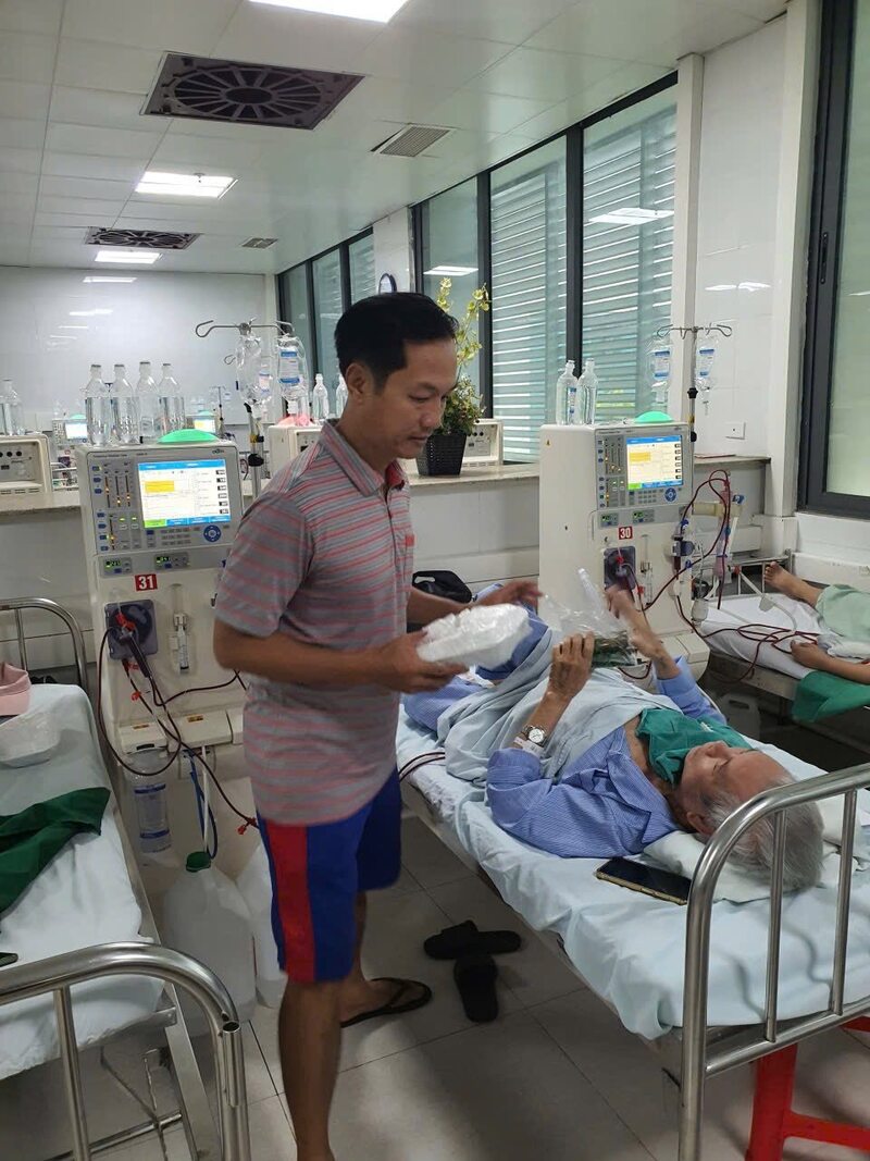 Ông Đào Minh Tuấn đang trao những suất cơm cho những người bệnh chạy thận. Ảnh: NVCC