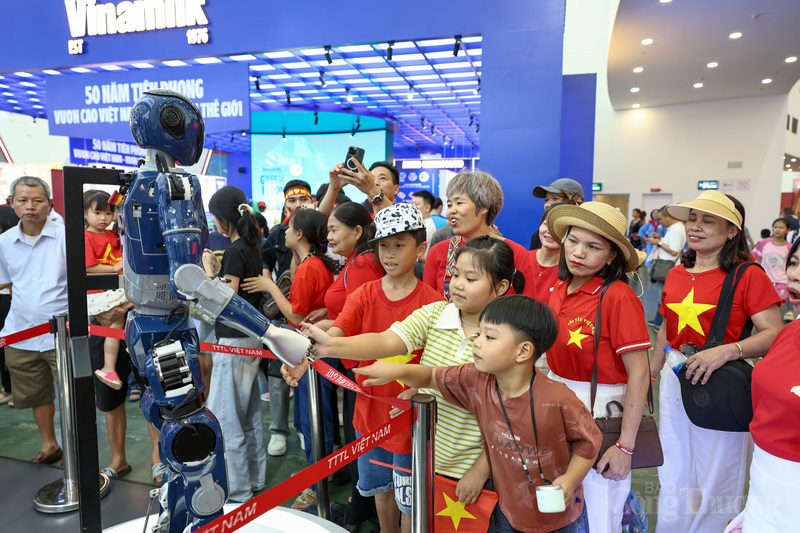 Một nhóm du khách nhí bắt tay thân thiện khi robot gọi tên từng bạn.