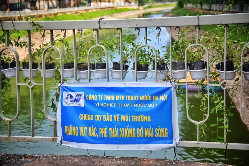 Bảng nhắc nhở giữ gìn vệ sinh môi trường được treo trên lan can bờ sông, kêu gọi người dân không vứt rác xuống dòng Tô Lịch.