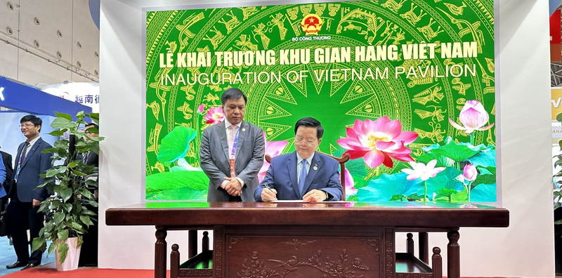 Phó Thủ tướng Mai Văn Chính ghi lưu bút tại Khu gian hàng Việt Nam. Ảnh: Vietrade