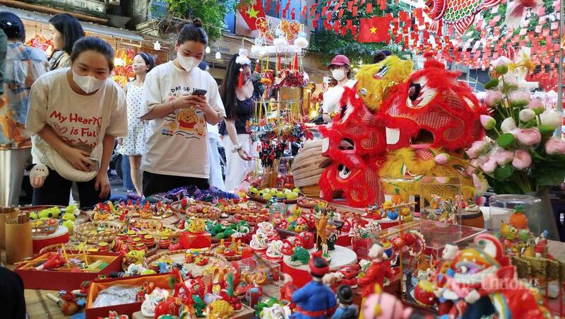 Khách hàng thích thú với gian hàng trò chơi tò he của nghệ nhân Đặng Văn Hậu trên phố Hàng Mã.
