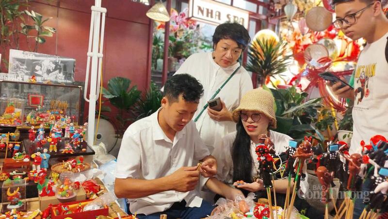 Nghệ nhân Đặng Văn Hậu tạo hình tò he tại gian hàng cho khách.