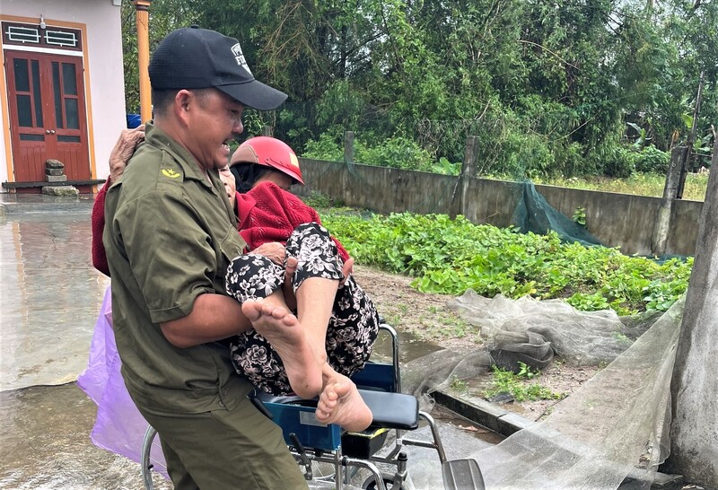 Lực lượng an ninh cơ sở xã Yên Hòa bế cụ già đến nơi tránh trú bão. Ảnh: Công an Hà Tĩnh