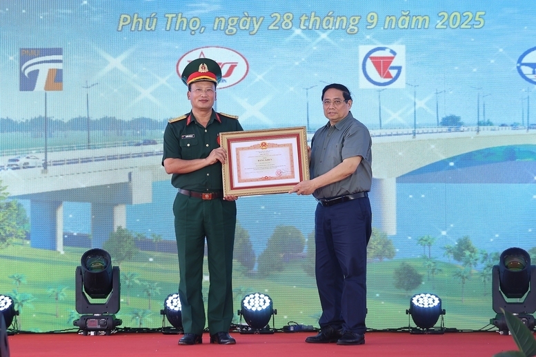 Thủ tướng Phạm Minh Chính trao Bằng khen của Thủ tướng Chính phủ tặng Đại tá Nguyễn Tuấn Anh, Phó Tư lệnh Binh đoàn 12 đã có thành tích xuất sắc trong xây dựng công trình - Ảnh: VGP/Nhật Bắc