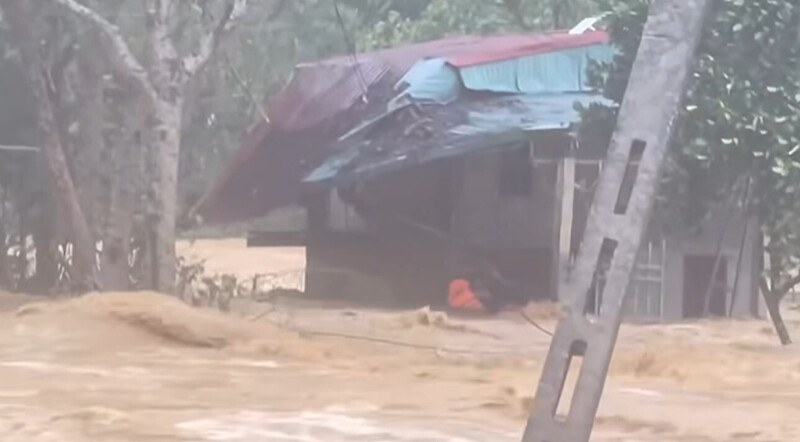 Lực lượng chức năng tiếp cận 2 nạn nhân khi đang chơi với giữa dòng nước lũ. Ảnh cắt từ clip