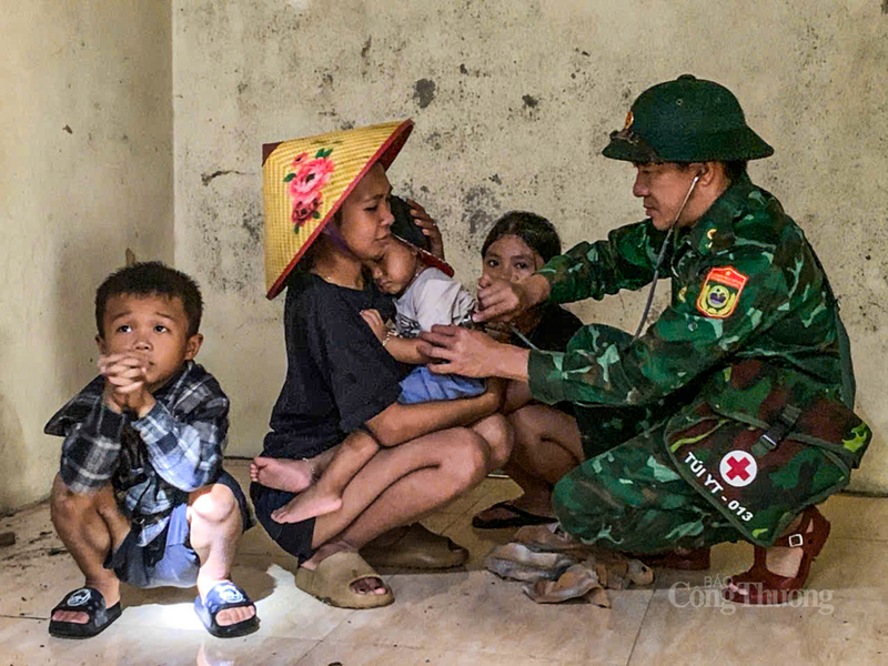 Thiếu tá Võ Văn Nam chăm sóc, khám chữa bệnh cho các em nhỏ tại khu tránh trú bão. Ảnh: Phúc Sơn.