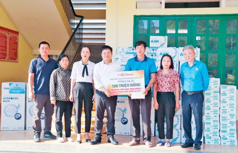Bí thư Đảng ủy, Tổng Biên tập Báo Công Thương Nguyễn Văn Minh (áo trắng) trao quà cho các trường bị thiệt hại sau bão Yagi tại Lào Cai