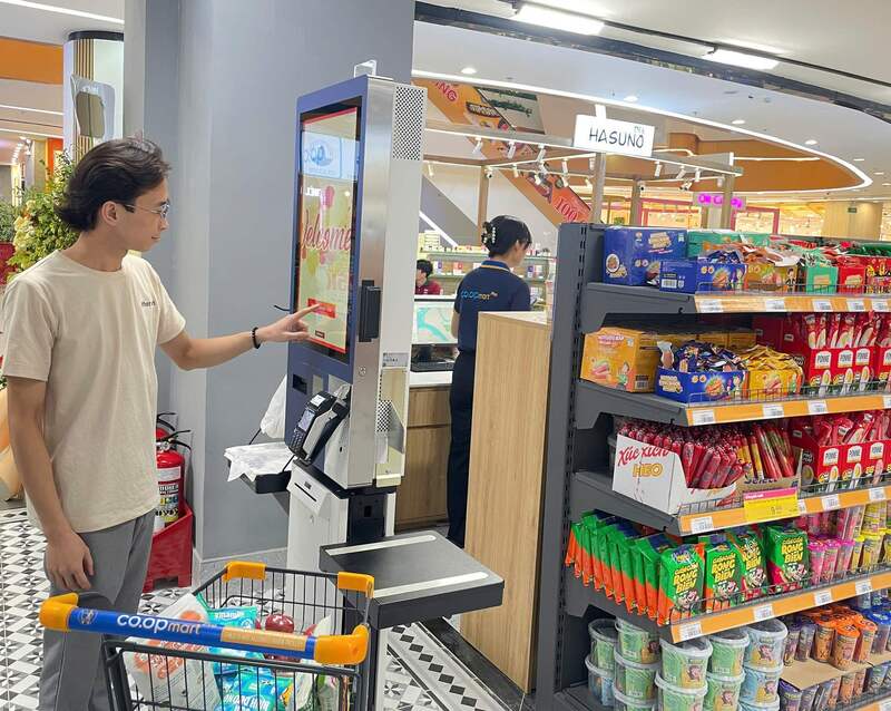 Khách hàng trải nghiệm hệ thống máy tính tiền tự động (Self-checkout)