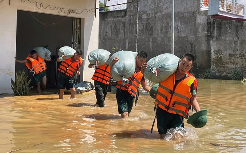 Lực lượng quân đội di chuyển, bảo vệ tài sản của người dân ra khỏi vùng lũ. Ảnh: Khánh Trình