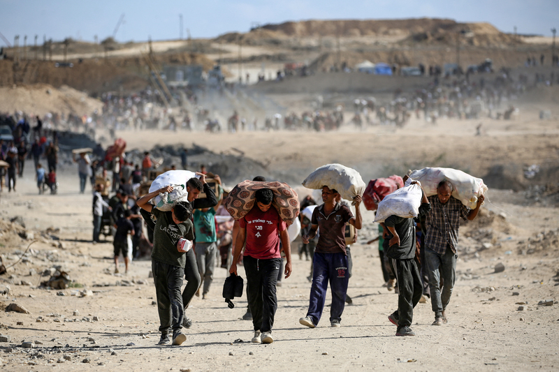 Người Palestine mang túi đồ rời điểm phát thực phẩm do Gaza Humanitarian Foundation (GHF), được Mỹ và Israel hỗ trợ, tổ chức gần hành lang Netsarim, Dải Gaza ngày 5/10/2025. Ảnh: AFP.