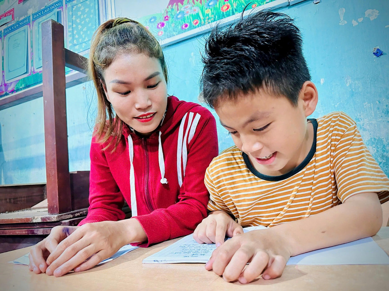 Người bạn đồng hành đặc biệt của Cái Mực Thảo là cậu con trai đang học lớp 5 ở trường xã. Ảnh: Nguyễn Dương
