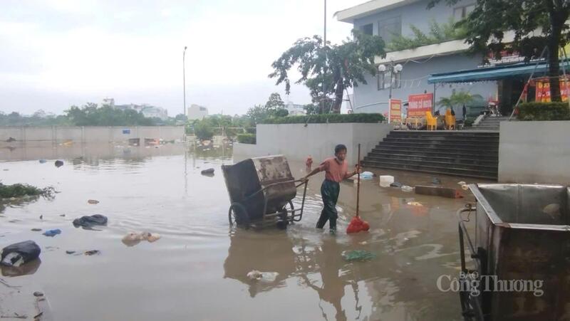 Công nhân lội nước dọn dẹp rác ở dưới nước.