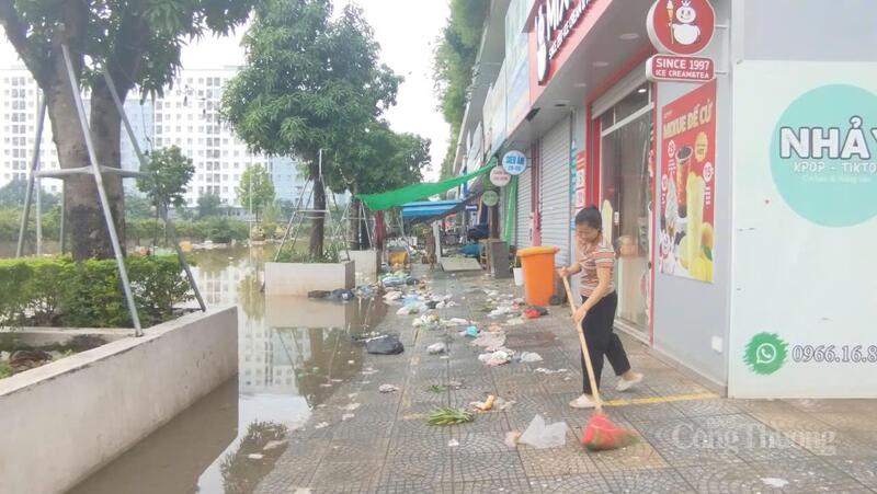 Người dân tranh thủ dọn dẹp rác thải khi nước bắt đầu rút.