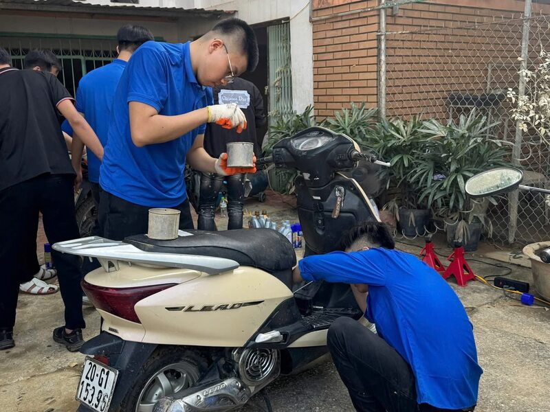 Các bạn sinh viên hỗ trợ người dân sửa lại xe máy, khắc phục hậu quả do bão lũ gây ra. Ảnh: EPU