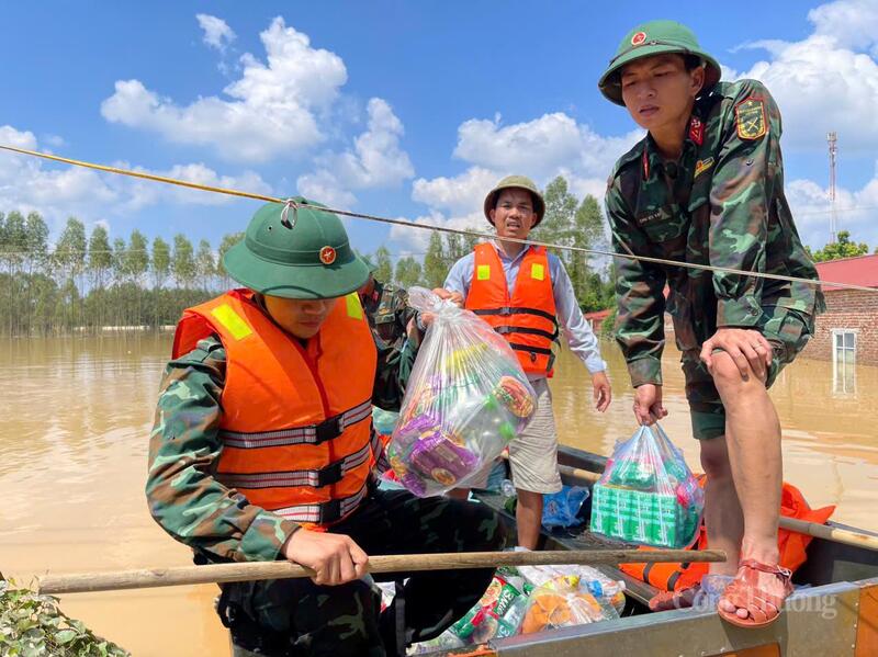 Dù chính ngôi nhà của mình vẫn chìm trong nước lũ, anh Chiến vẫn không ngơi nghỉ, ngày đêm cùng lực lượng quân đội lặn lội đến từng hộ dân để hỗ trợ bà con vùng ngập. Ảnh: TNTB