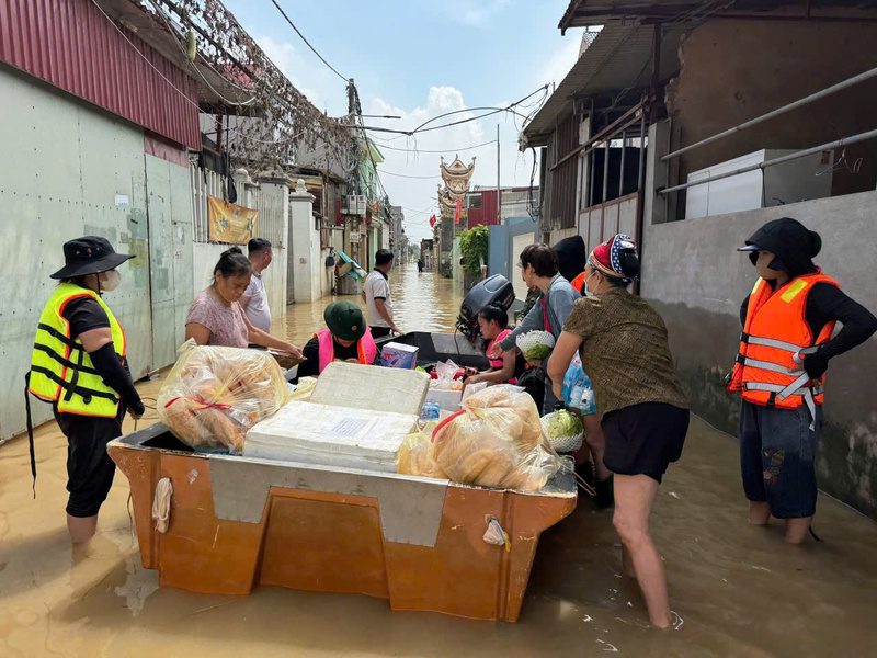 Vượt dòng lũ, đoàn cứu trợ cùng các lực lượng chức năng vẫn kiên trì mang nhu yếu phẩm vào từng khu vực bị cô lập, kịp thời hỗ trợ người dân. Ảnh: TNTB