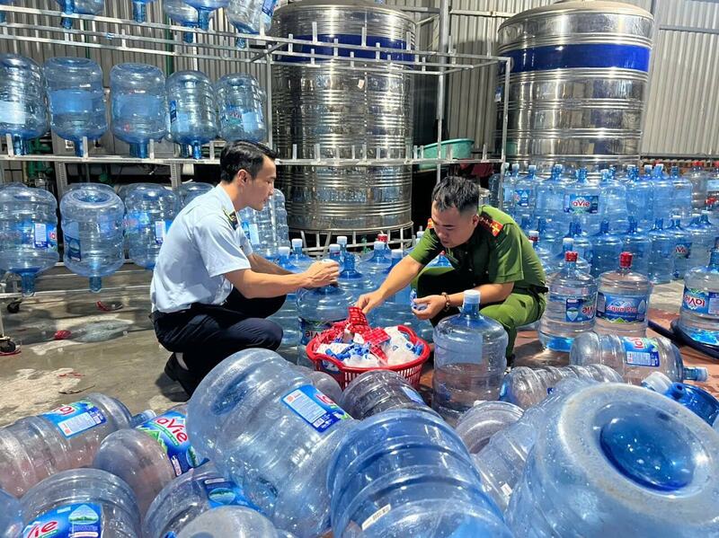 Cơ quan chức năng kiểm tra xưởng sản xuất nước của đối tượng Lê Văn Viết. Ảnh: Công an TP. Hà Nội cung cấp.