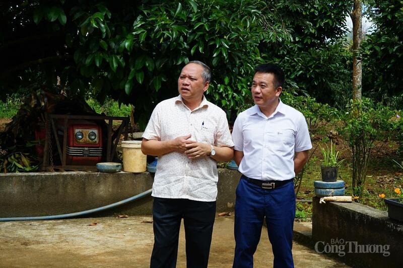 Ông Trần Nam Thuần, Chủ tịch UBND xã Tà Đùng (trái) trao đổi với ông Trần Viết Nguyên - Phó Ban kinh doanh và mua bán điện EVN. Ảnh: Vũ Long