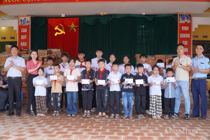 Đoàn công tác trao quà cho các em học sinh. Ảnh: Quỳnh Trang