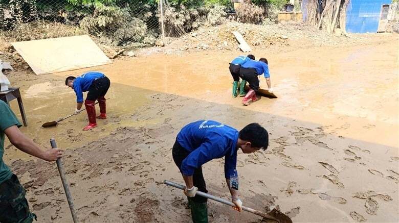 Sinh viên Trường Đại học Điện lực hỗ trợ người dân Thái Nguyên dọn sẹp sau lũ. Ảnh: NTCC