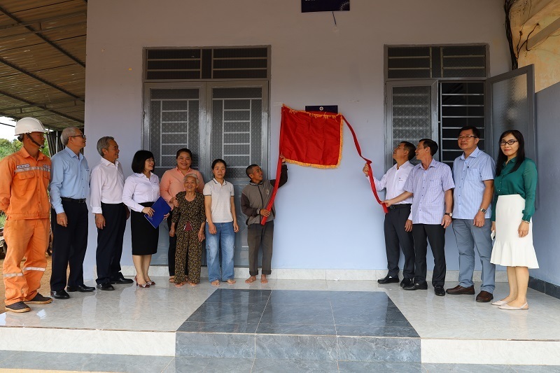 Các đại biểu và gia đình anh Nguyễn Hữu Dũng thực hiện nghi thức kéo băng khánh thành ngôi nhà