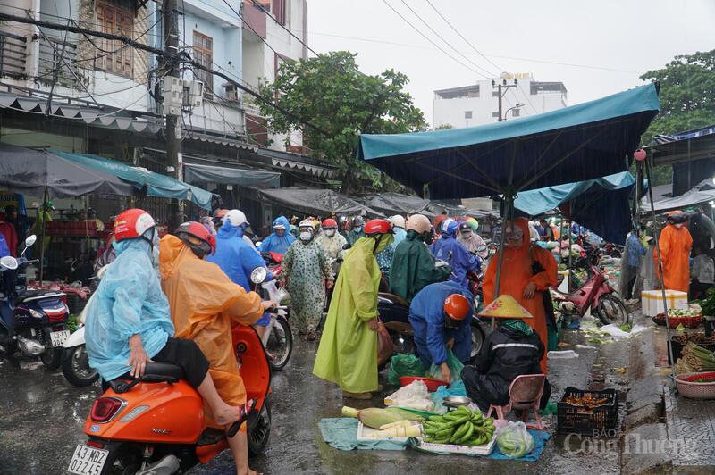 Người dân tranh thủ đi mua thực phẩm từ sáng sớm dù trời có mưa lớn.
