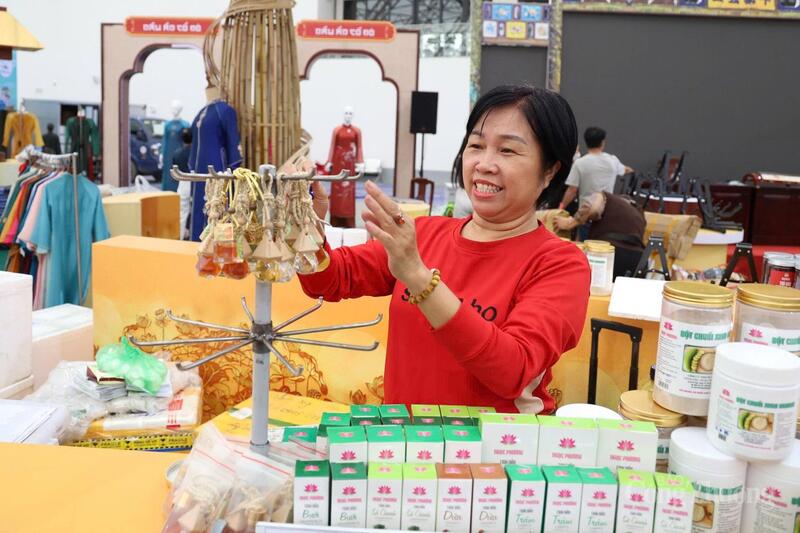 Bà Hồ Thị Khánh Ngọc - Giám đốc Công ty TNHH TMDV Tinh dầu nguyên chất Ngọc Phượng (Thành phố Huế) giới thiệu về một số sản phẩm đặc trưng, được trưng bày tại Hội chợ Mùa Thu 2025. Ảnh: Lê Vân.